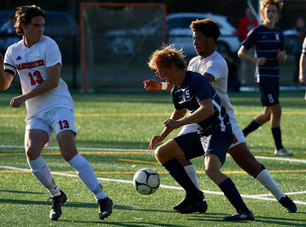 Hunter Smith shields the ball in Staples’ state tournament match - Mark Sikorski