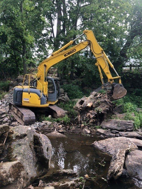 Workers dismantle a very old dam at the bottom of Bulkley Pond. It will allow fish and eels to once again reach the fresh water of Sasco Brook. / Photo by Sally Harold.