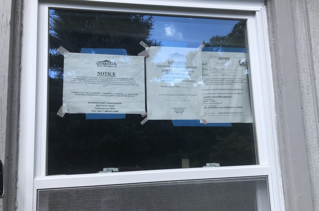 Notices in a window at 28 Pin Oak Court. The house has been vacant five years, since the owner died. Neighbors have concerns. / Photo by Thane Grauel.