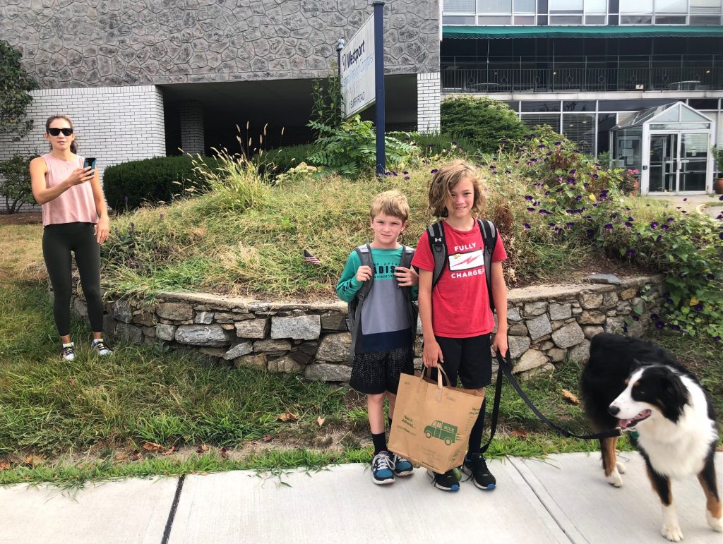 Connal Treanor, 7, a second-grader, and Sebastian McGunn, 9, a fourth-grader, with their dog, Trapper, waiting to cross Burr Road on Tuesday morning. / Photo by Thane Grauel.