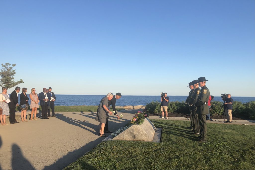 People lay flowers on names of those lost on Sept. 11 after a ceremony at Sherwood Island State Park. / Photo by Thane Grauel.