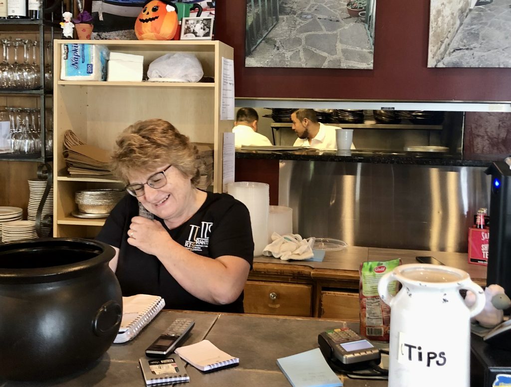Maria Funnicello, who opened Tutti's Ristorante in Saugatuck 20 years ago along with her husband, Pasquale, takes a reservation. / Photo by Thane Grauel