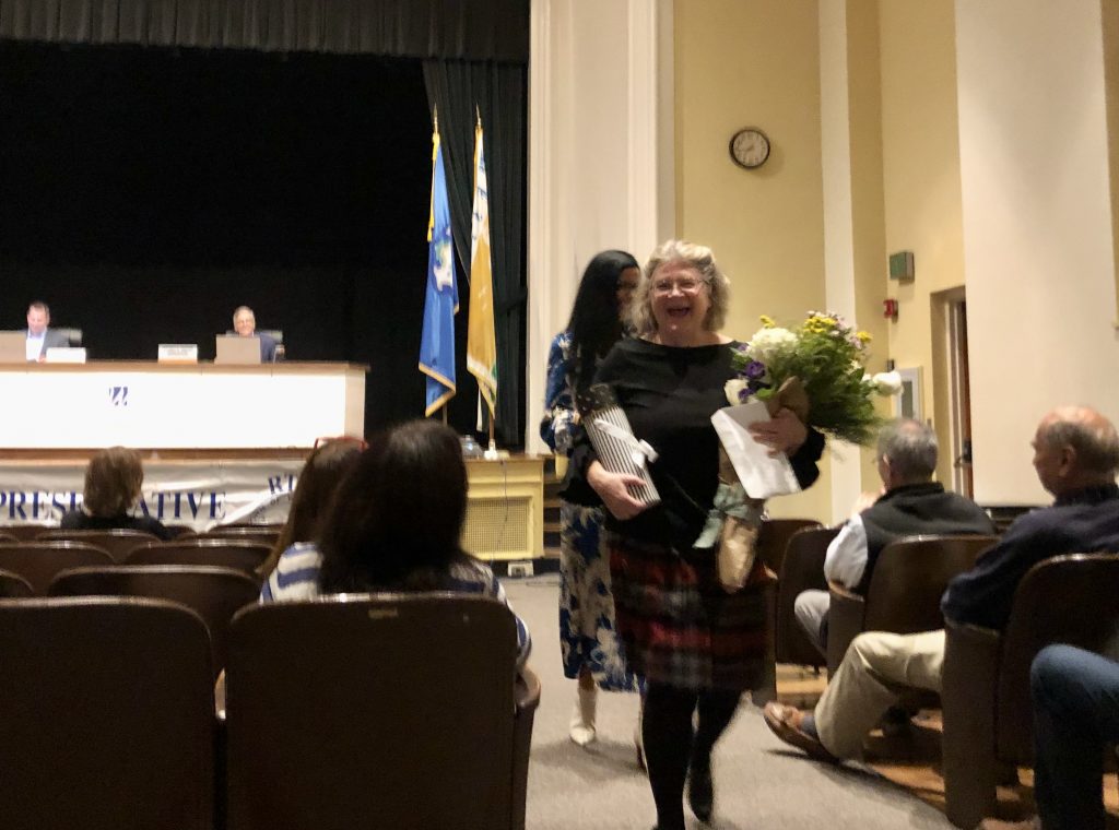 Outgoing Conservation Director Alicia Mozian was given a standing ovation, flowers, and other gifts at Tuesday's meeting of the Representative Town Meeting. / Photo by Thane Grauel