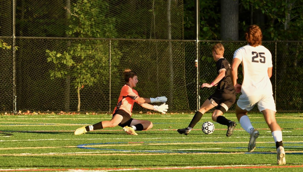 Nick Sikorski prepares to save a ball off the foot of dangerous attacker Owen Bull–Photo Mark Sikorski
