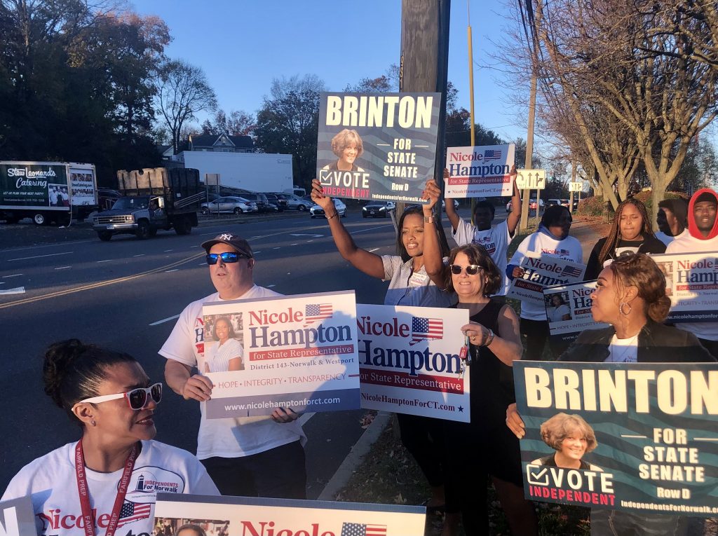 Nicole Hampton, center, holding a Brinton sign. Hampton is the Republican candidate for the 143 state House District, which includes portions of Norwalk and Westport. Here she and Brinton, standing next to her, wave to motorists outside Stew Leonard's on Monday. / Photo by Thane Grauel