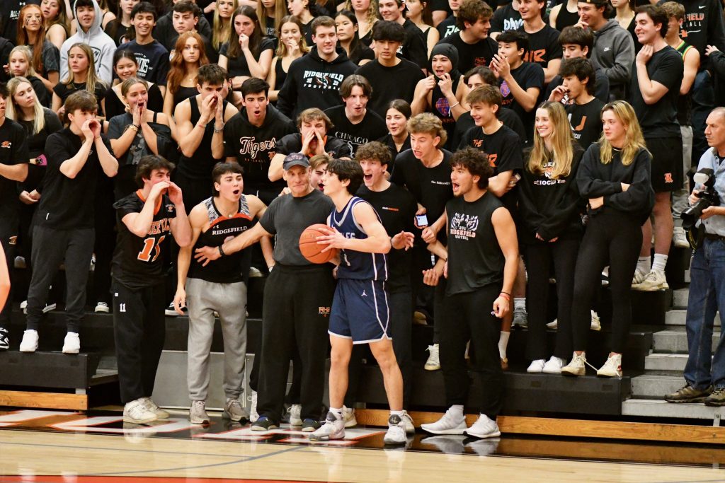 Adam Udell works an inbounds play with the loud Ridgefield crowd behind him - Photo Mark Sikorski
