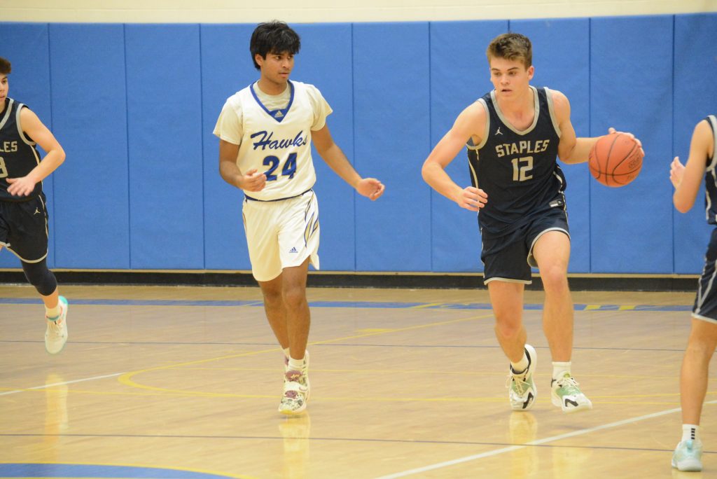 Chris Zajac heads up court with the ball during Staples' 48-47 come-from-behind win at Newtown on Tuesday - Photo Andy Hutchison