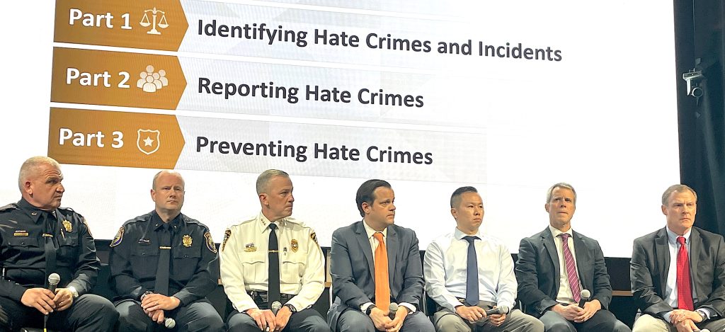 The panel presenting “United Against Hate” at the Westport Library included, from left: Westport Police Chief Foti Koskinas, Westport Deputy Police Chief Ryan Paulsson, Norwalk Police Chief James Walsh, Assistant U.S. Attorney Michael Nemec, Detective Alvin Chen of the Connecticut State Police, Michael Butcher of the FBI, and Bill Brown, assistant U.S. attorney, civil rights division.