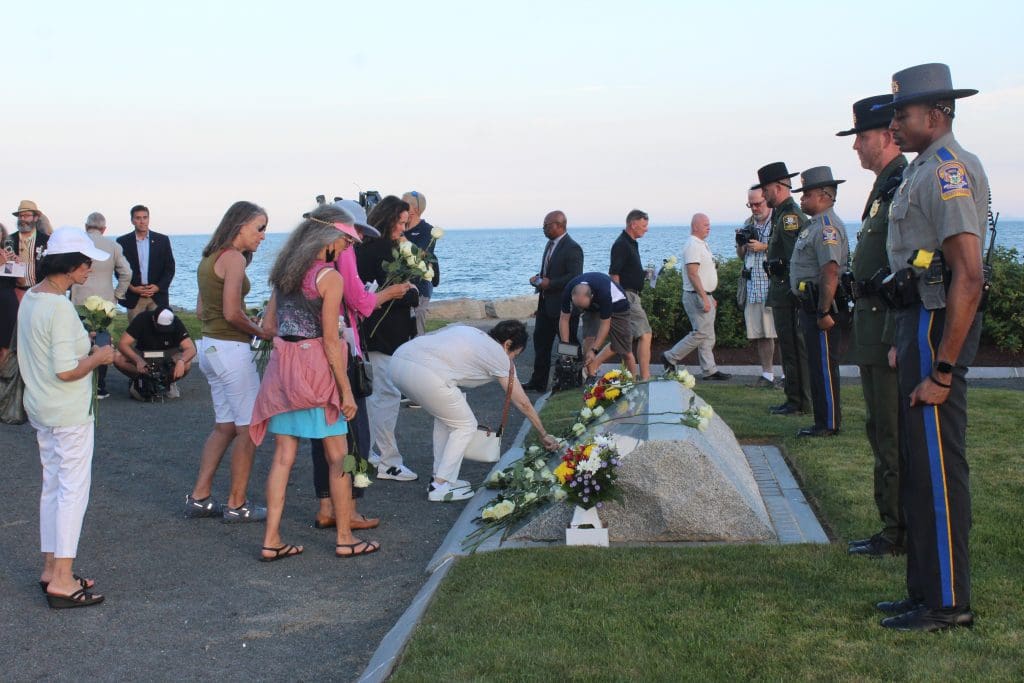 Family members, officials and others placed white roses at the Sept. 11 memorial.