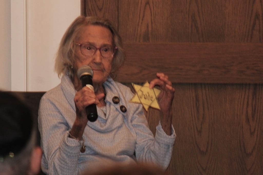 Esther Basch holds up a Jewish badge, like one she made to wear in her home village.