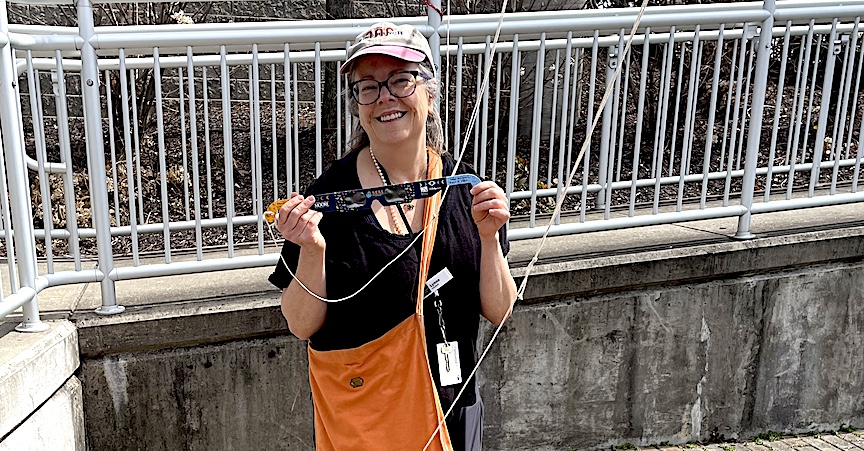 Lynne Perrigo, a children’s librarian, sets up a clothesline with safety glasses so those who don’t have a pair can “borrow” glasses to safely view the eclipse if Westport Library’s supply ran out