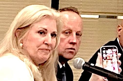 Board of Education member Jill Dillon demonstrates how to monitor cellphone usage at last week’s board meeting.