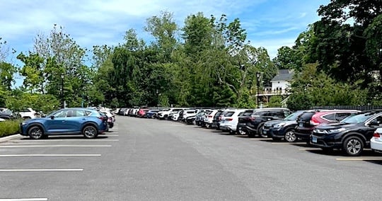 The Baldwin parking lot on Elm Street, where the upper spaces routinely were full before time limits were reintroduced recently, now has plenty of open three-hour spaces during the week, at left, while orange-striped all-day spaces are full, right.