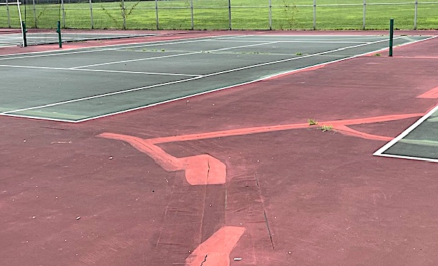 Cracks criss-cross the surface of the closed Doubleday tennis courts.