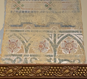 A section of the wall with the original painting exposed.