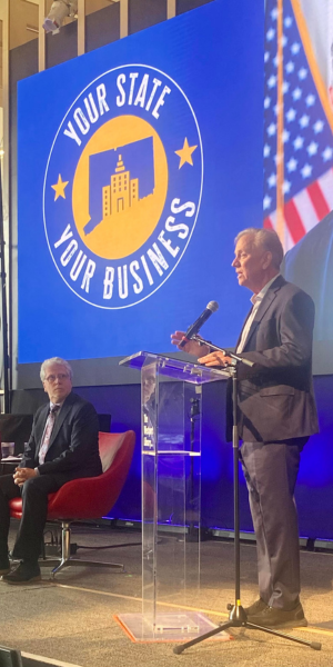 Governor Ned Lamont (standing) and Chamber of Commerce head Matthew Mandell - Photo Ken Valenti