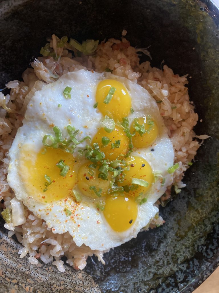 Crab rice with chorizo, topped with a layer of sunny-side-up quail eggs
